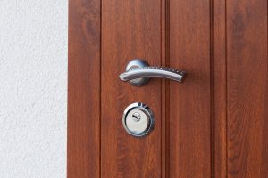 Detail of Modren style metallic door handle on wooden door